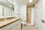 Primary bathroom with walk in shower, granite counters and high end tile floors